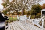 Main deck with grill and outdoor furniture overlooks the backyard and cranberry bog